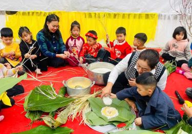 Cô giáo Nguyễn Thị Thu Trang - Hiệu trưởng Trường Mầm non Tân Đồng hướng dẫn các bé gói bánh chưng trong hoạt động trải nghiệm ở trường.