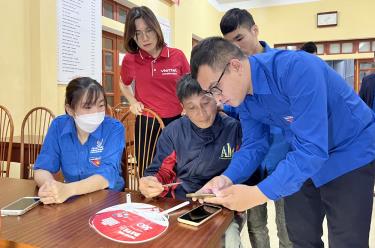 Thanh niên Yên Bái hỗ trợ người dân cài đặt các ứng dụng trên điện thoại thông minh.