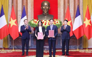 Trước sự chứng kiến của Chủ tịch nước Lương Cường và Tổng thống Pháp Emmanuel Macron, ông Ngô Chí Dũng, Tổng Giám đốc kiêm Chủ tịch HĐQT VNVC và bà Zainab Sadat Qayyum, Chủ tịch Sanofi Đông Nam Á - Ấn Độ trao văn kiện thỏa thuận hợp tác chuyển giao công nghệ sản xuất vắcxin của Sanofi