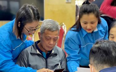 Đoàn viên thanh niên thành phố Yên Bái hỗ trợ người dân sử dụng các ứng dụng thanh toán không dùng tiền mặt trên điện thoại thông minh.