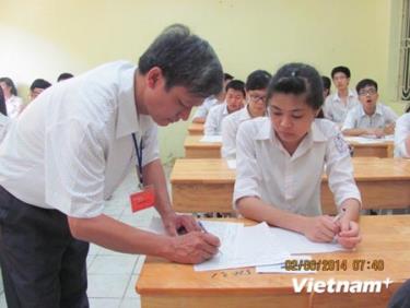 Giám thị ký vào giấy thi của thí sinh tại Hội đồng thi Trung học phổ thông Lê Quý Đôn, Hà Đông.