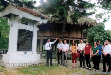 Cán bộ Phòng Văn hóa - Thông tin huyện Trấn Yên giới thiệu với khách tham quan về Khu di tích lịch sử Nhà ông Trần Đình Khánh.
