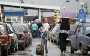 Hàng đoàn xe của người dân Ukraine nối đuôi nhau rời biên giới sang Nga.