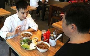 Le Van Tuan (trái), đầu bếp quán Uncle Ho, giới thiệu chi tiết về món bún chả với phóng viên.