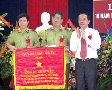 Thừa ủy quyền, đồng chí Tạ Văn Long - Ủy viên Ban Thường vụ Tỉnh uỷ, Phó chủ tịch UBND tỉnh trao cờ Thi đua của Ban Chỉ đạo 127/TW cho Chi cục Quản lý thị trường tỉnh Yên Bái năm 2011.