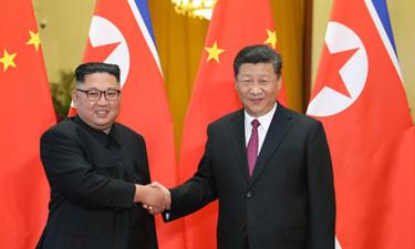 Kim Jong-un bắt tay Tập Cận Bình trong lễ đón tiếp ở Đại lễ đường nhân dân Bắc Kinh hôm 19/6.