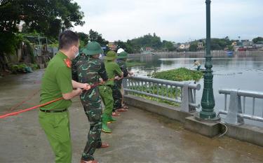Lực lượng vũ trang thành phố Yên Bái phối hợp với người dân di chuyển bèo, rác ra khỏi lòng hồ.