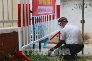 Nhân viên y tế đưa mẫu test nhanh cho cán bộ bệnh viện.