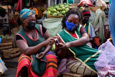 Người dân đeo khẩu trang và sát khuẩn tay phòng dịch COVID-19 tại một khu chợ ở Kampala, Uganda, ngày 23/6/2021.