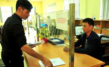 Cán bộ Chi cục Thuế thành phố Yên Bái hướng dẫn người dân nộp thuế trước bạ điện tử.