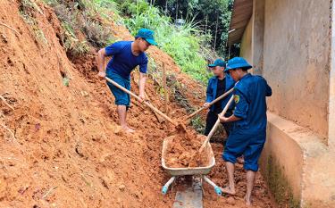 Dân quân xã Hồng Ca giúp gia đình bà Đoàn Thị Sửu, thôn Hồng Hải hót dọn đất bị sạt lở.