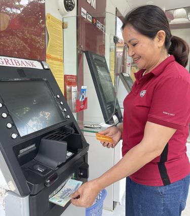 Bà Vũ Thị Thủy ở tổ dân phố số 9, thị trấn Mậu A rút tiền lương hưu tại cây ATM của ngân hàng.