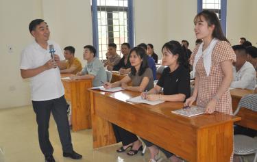 Học viên trao đổi với giảng viên Trung tâm Chính trị huyện Lục Yên tại lớp bồi dưỡng nhận thức chính trị cho đảng viên mới.
