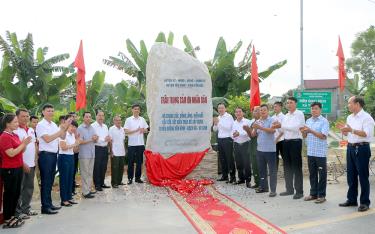 Các đồng chí lãnh đạo Sở Công Thương, lãnh đạo huyện Yên Bình và bà con nhân dân thực hiện nghi thức gắn biển tri ân sự đóng góp của nhân dân làm đường Yên Bình - Bạch Hà - Vũ Linh.