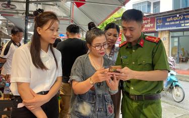 Cán bộ công an thị trấn Yên Thế hướng dẫn người dân sử dụng ứng dụng VNeID để góp ý sửa đổi, bổ sung Hiến pháp 2013.