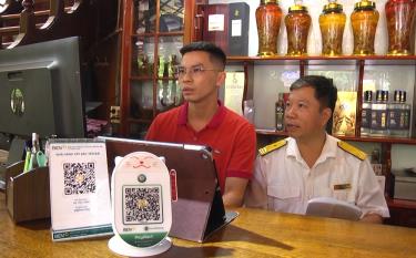 Cán bộ Đội thuế liên huyện Yên Bái - Yên Bình hướng dẫn hộ kinh doanh đăng ký, sử dụng hóa đơn điện tử khởi tạo từ máy tính tiền.
