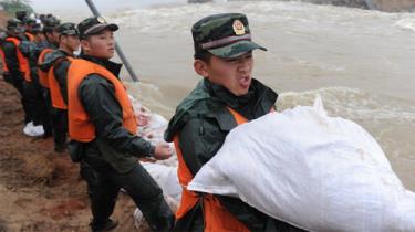 Binh sĩ Trung Quốc đắp bờ bao ngăn lũ dữ.