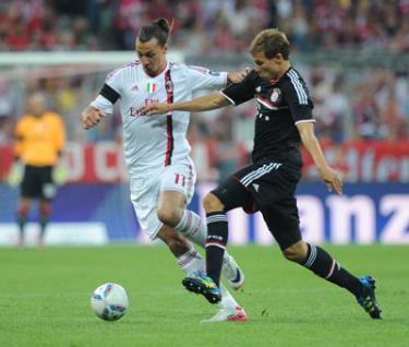 Zlatan Ibrahimovic (trái, AC Milan) đi bóng trước hậu vệ Holger Badstuber của Bayern Munich.