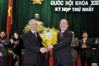 Chủ tịch Quốc hội khoá XIII Nguyễn Sinh Hùng tặng hoa Chủ tịch Quốc hội khoá XII Nguyễn Phú Trọng. (Nguồn: vov.nv) 
