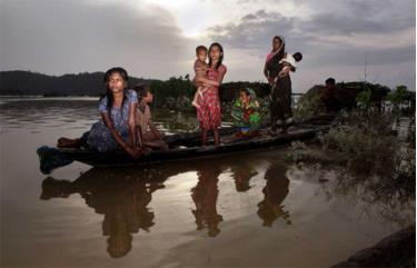 Một gia đình ngồi trên thuyền ở Tin Tukra, bang Assam ngày 30/6/2012.