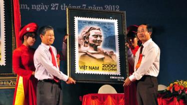 Đại diện UBND tỉnh Quảng Nam trao biểu tượng mẫu tem cho gia đình mẹ Việt Nam anh hùng Nguyễn Thị Thứ.