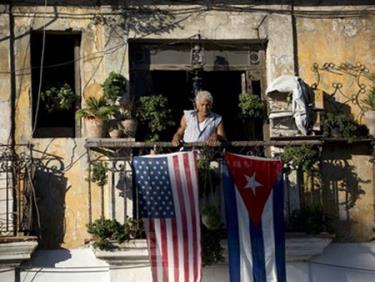 Một người dân treo cờ Mỹ và Cuba ở ban công của một ngôi nhà tại La Habana của Cuba.
