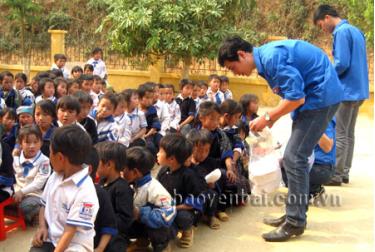 Thanh niên tình nguyện tặng dép cho trẻ em vùng cao ở huyện Mù Cang Chải.
