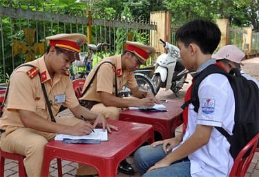 Lực lượng cảnh sát giao thông nhắc nhở, xử lý học sinh vi phạm.