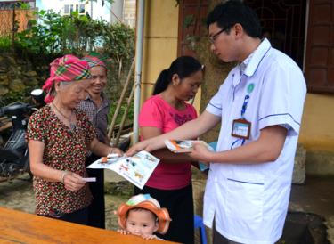 Cán bộ y tế xã An Lương, huyện Văn Chấn phát tờ rơi tuyên truyền phòng, chống bệnh dại cho nhân dân.