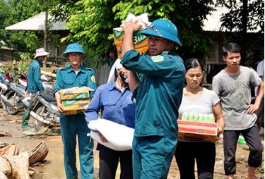 Lực lương dân quân tự vệ vận chuyển lương thực hỗ trợ cho người dân vùng lũ.