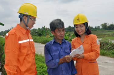 Công nhân ngành điện tuyên truyền tiết kiệm điện mùa nắng nóng cho người dân.