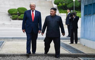 Tổng thống Mỹ Donald Trump (trái) và nhà lãnh đạo Triều Tiên Kim Jong-un bước chân qua đường ranh giới phân chia hai miền Triều Tiên tại DMZ, sang phần lãnh thổ của Triều Tiên.