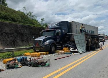 Sau cú va chạm với xe khách, xe tải đâm vào xe container rồi lật nghiêng trên đường.