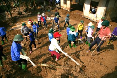 Cán bộ, giáo viên ngành giáo dục và đào tạo Văn Chấn giúp nhân dân khắc phục mưa lũ ở xã Sơn Lương tháng 7 năm 2018.