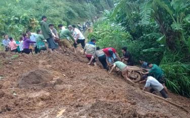 Người dân hỗ trợ đưa xe máy của chị Lò Thị Châu (ở tỉnh Lai Châu) từ dưới vực lên.