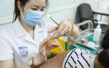 Nhân viên y tế tiêm thử nghiệm vaccine phòng COVID-19 cho tình nguyện viên.