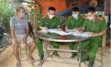 Chủ mỏ khai thác đá trái phép Trần Văn Bảy làm việc với cơ quan điều tra - Ảnh: CAND
