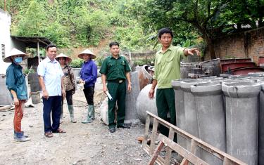 Cựu chiến binh Nguyễn Văn Khát (ngoài cùng bên phải) giới thiệu với lãnh đạo Hội CCB huyện, xã về quy trình sản xuất cống bi thoát nước.
