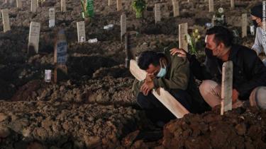 Một người đàn ông đang tưởng niệm người thân được chôn cất tại một nghĩa trang ở Jakarta.