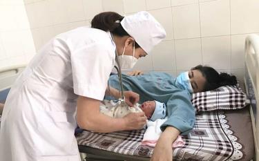 A doctor of the medical centre of Yen Bai city guides a mother in how to care for her newborn baby.