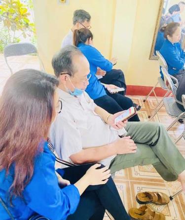 Đoàn viên thanh niên thành phố Yên Bái hướng dẫn người dân sử dụng các ứng dụng tiện ích trên điện thoại thông minh.