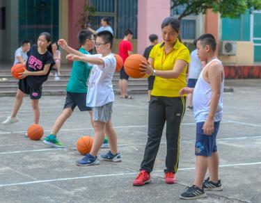 Chị Nguyễn Thanh Bảy hướng dẫn học sinh từng động tác cơ bản với trái bóng.