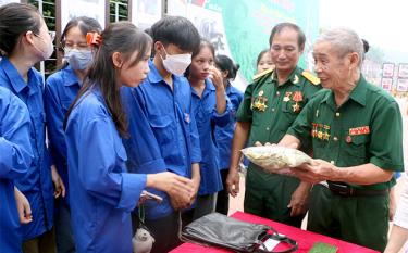 Các bạn trẻ có mặt tại trưng bày được thông tin về các kỷ vật chiến tranh.