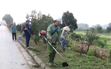 Hội viên Hội Phụ nữ xã Nga Quán phối hợp với các đoàn thể tổ chức lao động vệ sinh tuyến đường hoa Yên Bái - Khe Sang.