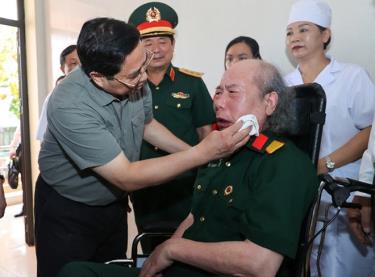 Thủ tướng Phạm Minh Chính chia sẻ với một thương binh tại Trung tâm Điều dưỡng thương binh Nho Quan, Ninh Bình