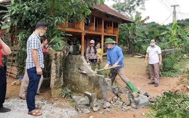 Người dân xã Mường Lai tự nguyện phá tường rào hiến đất mở rộng đường.