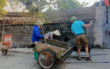 Các thành viên Tổ tự quản tham gia dọn dẹp vệ sinh môi trường, làm nắp mương để mở rộng đường giao thông nông thôn.