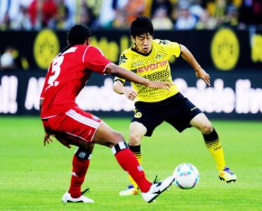 Tiền vệ Shinji Kagawa (phải, Dortmund) đi bóng trước hậu vệ Michael Mancienne của Hamburg.