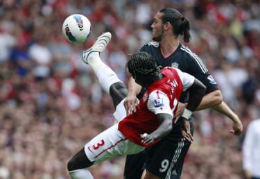 Hậu vệ Sagna (số 3, Arsenal) cố gắng truy cản tiền đạo Carroll của Liverpool.