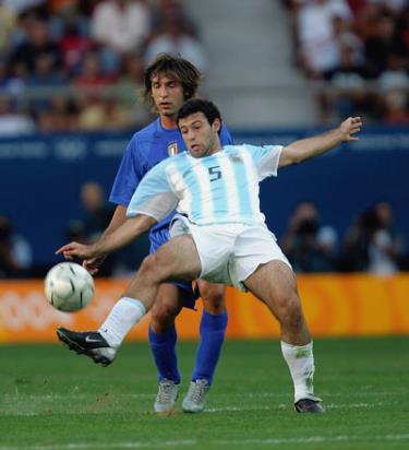 Andrea Pirlo (Italia, trái) tranh bóng với hậu vệ Javier Mascherano (Argentina).